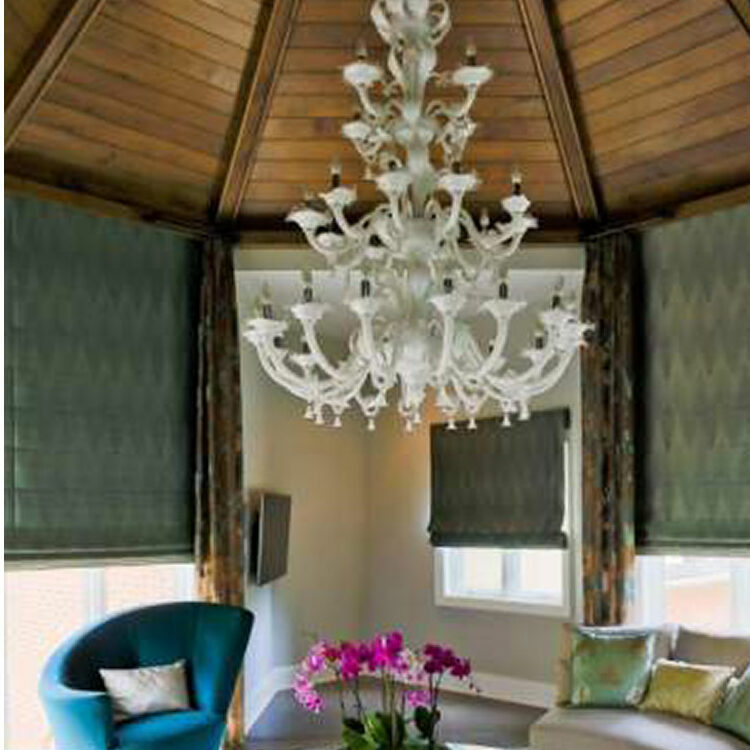 A white chandelier hanging over a table in a living area that was part of a home addition.